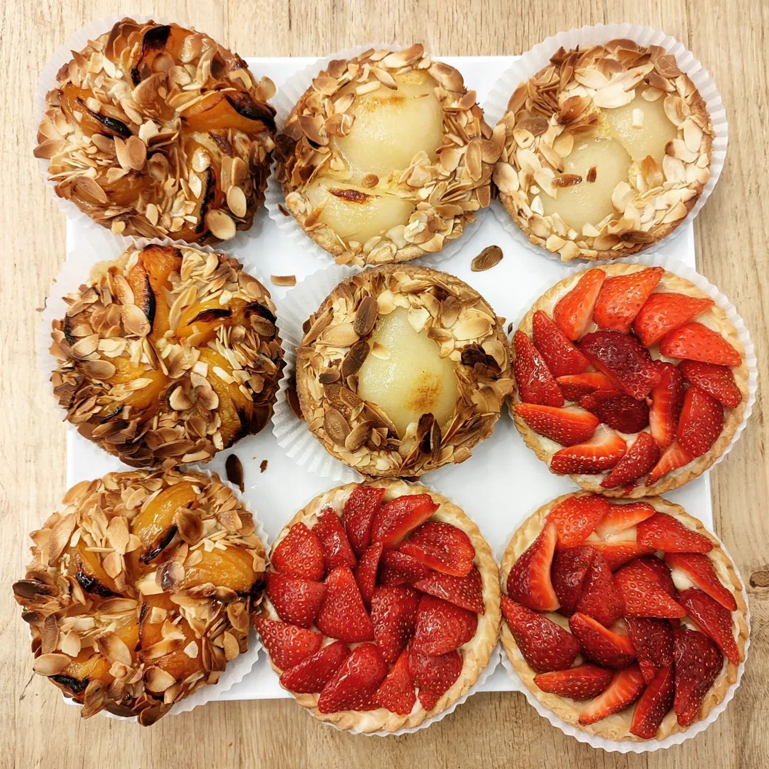 Un plateau de tartelettes aux amandes et aux fruits, dont des fraises
